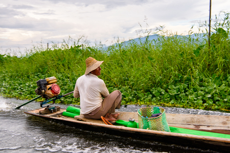 INLE LAKE, MYANMAR - AUG 30, 2016: Unidentified Burmese man in bamboo boat sails over the Inle Sap,a freshwater lake located in the Nyaungshwe Township of Taunggyi District of Shan State, Myanmarのeditorial素材