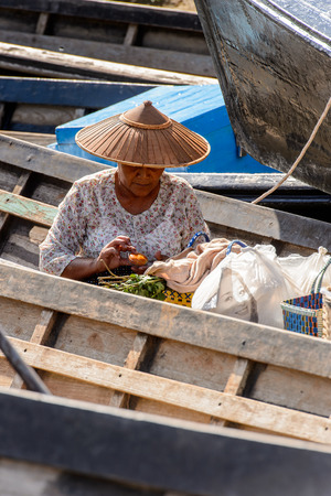 INLE LAKE, MYANMAR - AUG 30, 2016: Unidentified Burmese woman on a wooden boat over the Lake Inle. 68 per cent of Myanma people belong to Bamar ethnic groupのeditorial素材