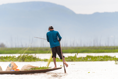 INLE LAKE, MYANMAR - AUG 30, 2016: Unidentified Burmese man in bamboo boat sails over the Inle Sap,a freshwater lake located in the Nyaungshwe Township of Taunggyi District of Shan State, Myanmarのeditorial素材