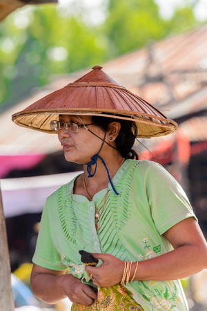 INLE LAKE, MYANMAR - AUG 30, 2016: Unidentified Burmese woman in a traditional hat. 68 per cent of Myanma people belong to Bamar ethnic groupのeditorial素材