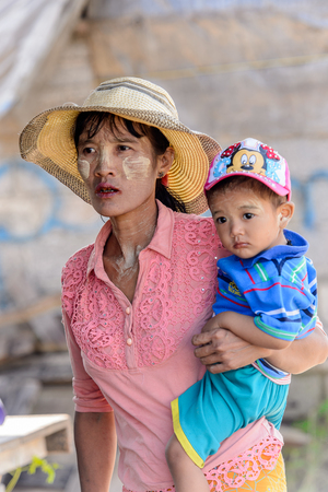 INLE LAKE, MYANMAR - AUG 30, 2016: Unidentified Burmese woman with her child. 68 per cent of Myanma people belong to Bamar ethnic groupのeditorial素材