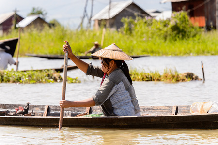 INLE LAKE, MYANMAR - AUG 30, 2016: Unidentified Burmese man in a wooden boat. 68 per cent of Myanma people belong to Bamar ethnic groupのeditorial素材