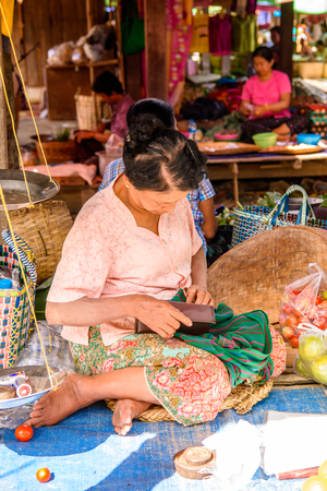 INLE LAKE, MYANMAR - AUG 30, 2016: Unidentified Burmese woman works at the market place, the Inle Sap,a freshwater lake  in the Nyaungshwe Township of Taunggyi District of Shan State, Myanmarのeditorial素材