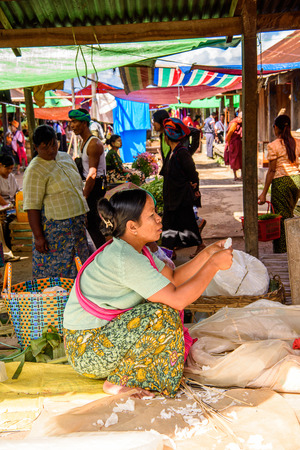 INLE LAKE, MYANMAR - AUG 30, 2016: Unidentified Burmese woman works at the market place, the Inle Sap,a freshwater lake  in the Nyaungshwe Township of Taunggyi District of Shan State, Myanmarのeditorial素材