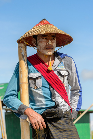 INLE LAKE, MYANMAR - AUG 30, 2016: Unidentified Burmese man on a wooden boat. 68 per cent of Myanma people belong to Bamar ethnic groupのeditorial素材