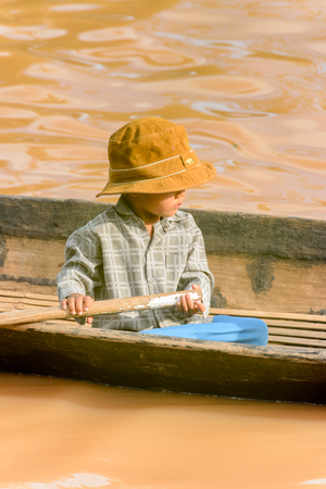 INLE LAKE, MYANMAR - AUG 30, 2016: Unidentified Burmese little boy in a wooden boat. 68 per cent of Myanma people belong to Bamar ethnic groupのeditorial素材