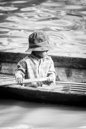 INLE LAKE, MYANMAR - AUG 30, 2016: Unidentified Burmese little boy in a wooden boat. 68 per cent of Myanma people belong to Bamar ethnic groupのeditorial素材