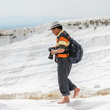 PAMUKKALE, TURKEY - APR 18, 2015: Unidentified tourist  in a hat on the travertines of Pamukkale, Turkey. It's a UNESCO World Heritage siteのeditorial素材