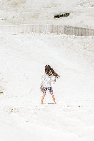 PAMUKKALE, TURKEY - APR 18, 2015: Unidentified girl walks on the travertines of Pamukkale, Turkey. It's a UNESCO World Heritage siteのeditorial素材