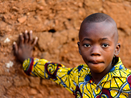 MASSIF KABYE, TOGO - JAN 13, 2017: Unidentified Togolese little boy in colored shirt looks ahead in the village. Togo children suffer of poverty due to the bad economy.のeditorial素材