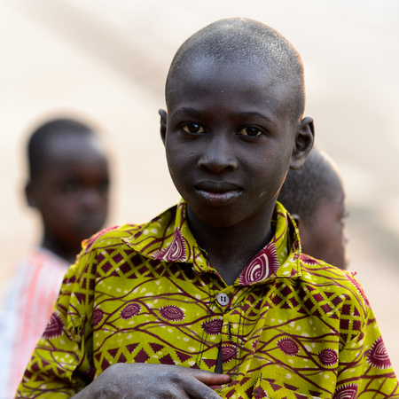 MASSIF KABYE, TOGO - JAN 13, 2017: Unidentified Togolese  little boy in colored shirt looks ahead in the village. Togo children suffer of poverty due to the bad economy.のeditorial素材