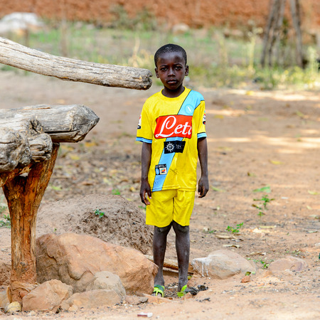 KARA REG., TOGO - JAN 14, 2017: Unidentified Konkomba     little boy in yellow suit stands in the village. Konkombas are ethnic group of Togoのeditorial素材