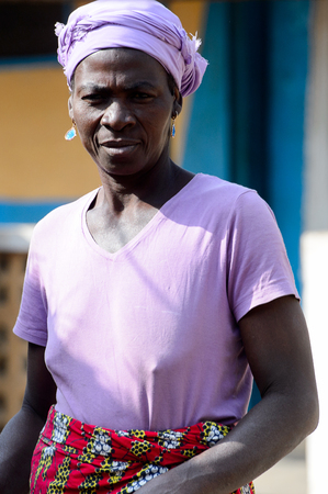 KARA REG., TOGO - JAN 14, 2017: Unidentified Konkomba woman in purple clothes and headscarf walks in the village. Konkombas are ethnic group of Togoのeditorial素材