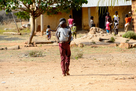 KARA REG., TOGO - JAN 14, 2017: Unidentified Konkomba woman carries a baby in the village. Konkombas...