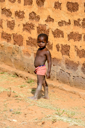 KARA REG., TOGO - JAN 14, 2017: Unidentified Konkomba little girl walks in the street in the village. Konkombas are ethnic group of Togoのeditorial素材