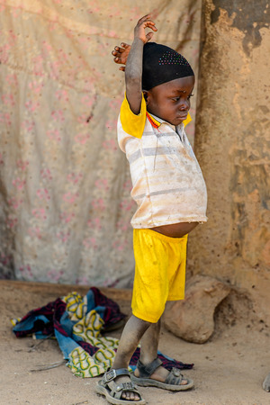 KARA REG., TOGO - JAN 14, 2017: Unidentified Konkomba little boy plays on the street in the village. Konkombas are ethnic group of Togoのeditorial素材