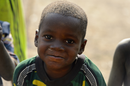 GHANI, GHANA - JAN 14, 2017: Unidentified Ghanaian little boy looks ahead in the Ghani village. Ghana children suffer of poverty due to the bad economy.のeditorial素材