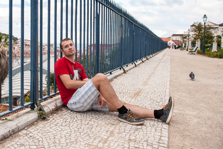 LISBON, PORTUGAL - JUN 20, 2014: Unidentified man sits and enjos the beautiful panoramic view of Lisbon, Portugal. Lisbon is the westernmost large city Europe and the seventh-most-visited city in Southern Europeのeditorial素材