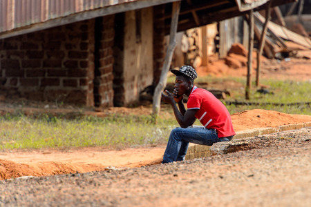 TECHIMAN, GHANA - JAN 15, 2017: Unidentified Ashanti  man talks on the cellphone in the local village. Ashante are ethnic group of Ghanaのeditorial素材