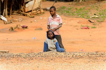 TECHIMAN, GHANA - JAN 15, 2017: Unidentified Ashanti boy wears hood and sits in the local village. Ashante are ethnic group of Ghanaのeditorial素材
