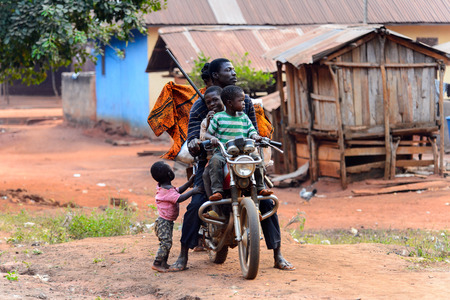 BOABENG, GHANA - JAN 15, 2017: Unidentified Ghanaian  man rides a motorcycle with his children in the local village. Ghana people suffer of poverty due to the bad economy.のeditorial素材