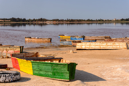 LAC ROSE, SENEGAL - APR 26, 2017: Wooden boats on the coast of the Lake Retba with the red water, UNESCO WOrld Heritageのeditorial素材