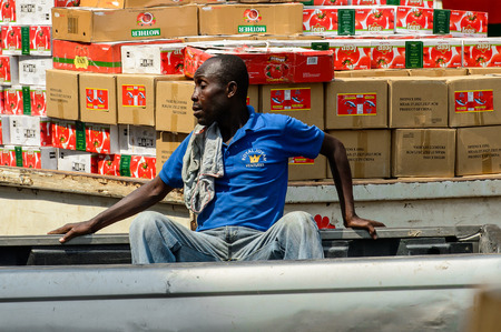 KUMASI, GHANA - JAN 15, 2017: Unidentified Ghanaian man sits on the car trunk at the Kumasi market. Ghana people suffer of poverty due to the bad economy.のeditorial素材