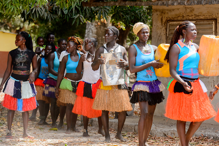 ORANGO ISL., GUINEA BISSAU - MAY 3, 2017: Unidentified local Women dance and hold canisters during Vaca Bruto, traditional Mask danceのeditorial素材