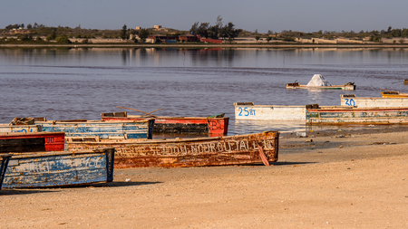 LAC ROSE, SENEGAL - APR 26, 2017: Wooden boats on the coast of the Lake Retba with the red water, UNESCO WOrld Heritageのeditorial素材