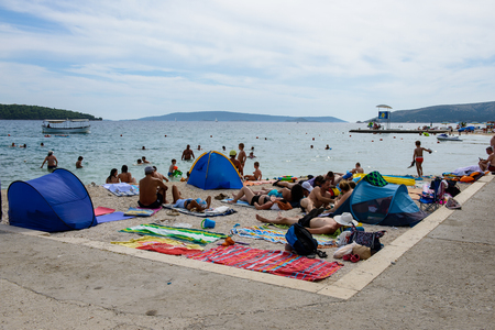 DALMATIA, REGION OF SPLIT, CROATIA - AUG 20, 2014: Unidentified people on a beach of the Adriatic coast. Coast of the Adriatic Sea in Dalmatia became a popular destination for millions of touristsのeditorial素材