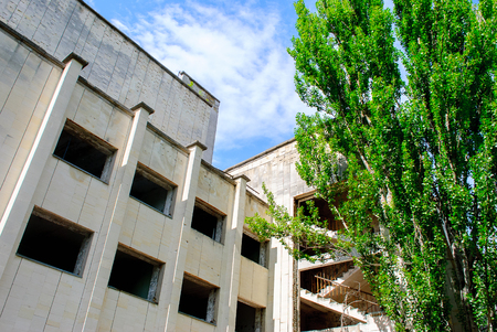 Abandoned building surrounded  by green trees rowing in the centre in Pripyat, a ghost town in northern Ukraine, evacuated the day after the Chernobyl disaster on April 26, 1986の写真素材