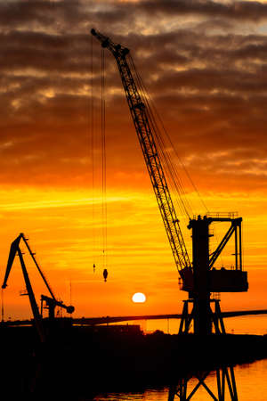 Construction cranes on the Sunset over the sea in Russiaの写真素材