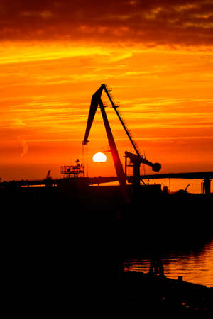 Construction cranes on the Sunset over the sea in Russiaの写真素材