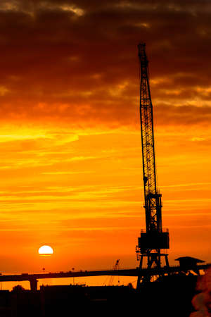 Construction cranes on the Sunset over the sea in Russiaの写真素材