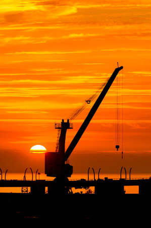 Construction cranes on the Sunset over the sea in Russiaの写真素材