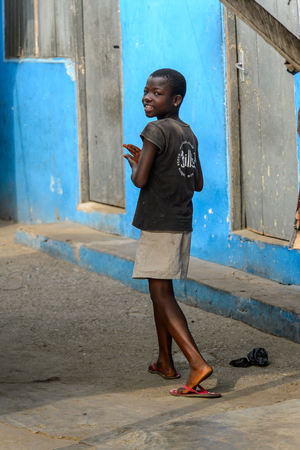 ACCRA, GHANA - JAN 8, 2017: Unidentified Ghanaian girl walks in the street. Children of Ghana suffer of poverty due to the economic situationのeditorial素材