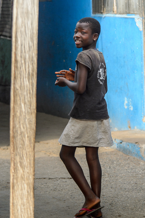 ACCRA, GHANA - JAN 8, 2017: Unidentified Ghanaian girl walks in the street. Children of Ghana suffer of poverty due to the economic situationのeditorial素材