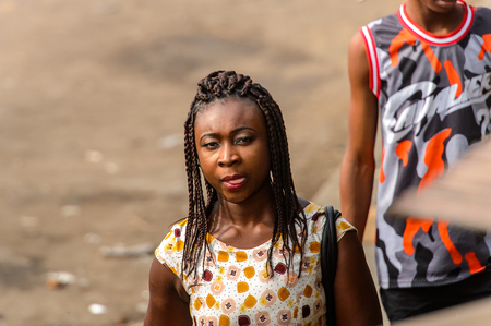 ACCRA, GHANA - JAN 8, 2017: Unidentified Ghanaian woman wears braids on her head and shows her tongue. People of Ghana suffer of poverty due to the economic situationのeditorial素材