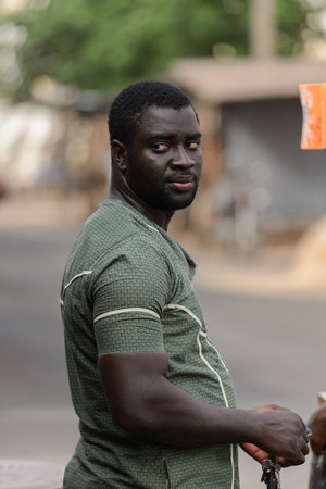 LOME, TOGO - Jan 9, 2017: Unidentified Togolese man in green shirt holds a bunch of keys in his hands at the Lome central market. Togo people suffer of poverty due to the bad economyのeditorial素材