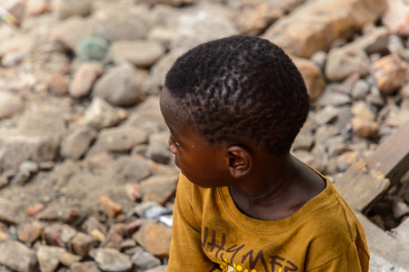 ACCRA, GHANA - JAN 8, 2017: Unidentified Ghanaian little boy in mustard shirt from behind. Children of Ghana suffer of poverty due to the economic situationのeditorial素材