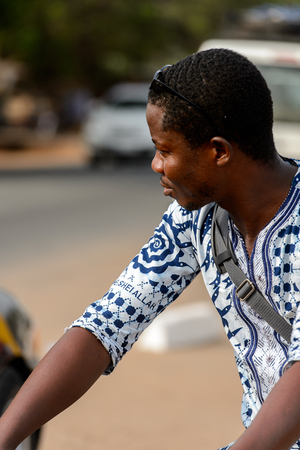 ACCRA, GHANA - JAN 8, 2017: Unidentified Ghanaian man in white and blue shirt looks away. People of Ghana suffer of poverty due to the economic situationのeditorial素材