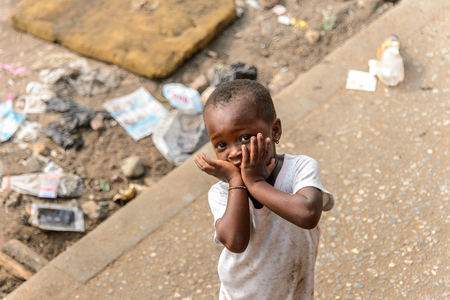ACCRA, GHANA - JAN 8, 2017: Unidentified Ghanaian little girl in dirty white dress  on the street. Children of Ghana suffer of poverty due to the economic situationのeditorial素材