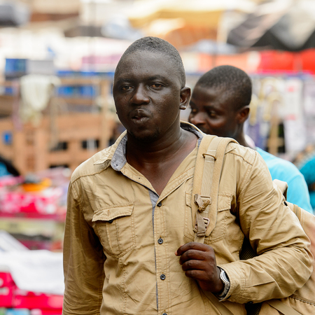 LOME, TOGO - Jan 9, 2017: Unidentified Togolese man in shirt at the Lome central market. Togo people suffer of poverty due to the bad economyのeditorial素材