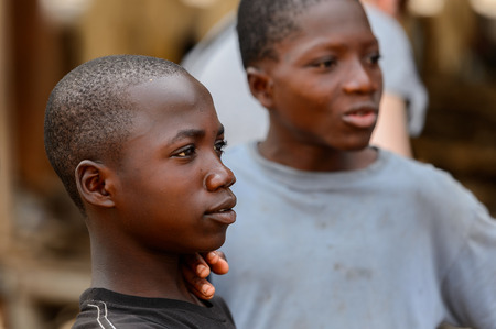 LOME, TOGO - Jan 9, 2017: Unidentified Togolese two boys look away at the Lome fetish market. Togo people suffer of poverty due to the bad economyのeditorial素材