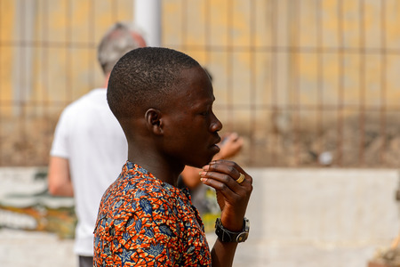 LOME, TOGO - Jan 9, 2017: Unidentified Togolese boy thoughtfully looks away at the Lome fetish market. Togo people suffer of poverty due to the bad economyのeditorial素材