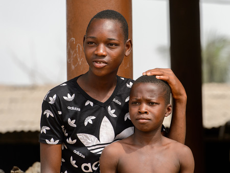 LOME, TOGO - Jan 9, 2017: Unidentified Togolese boy touches his friend's head at the Lome fetish market. Togo people suffer of poverty due to the bad economyのeditorial素材