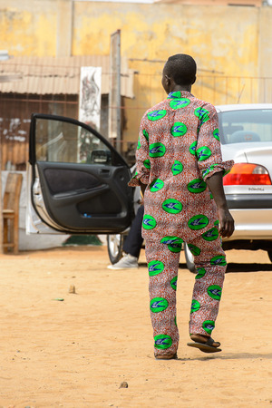 LOME, TOGO - Jan 9, 2017: Unidentified Togolese man in colored suit from behind at the Lome fetish market. Togo people suffer of poverty due to the bad economyのeditorial素材