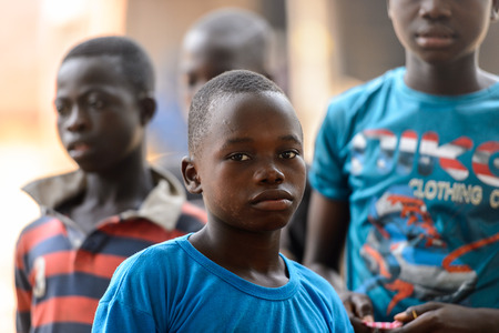 LOME, TOGO - Jan 9, 2017: Unidentified Togolese  boy in blue shirk has deep look at the Lome fetish market. Togo people suffer of poverty due to the bad economyのeditorial素材
