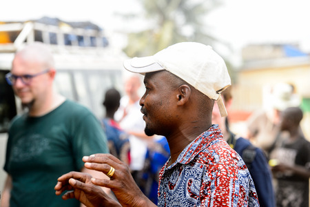 LOME, TOGO - Jan 9, 2017: Unidentified Togolese man in white hat raises his hands at the Lome fetish market. Togo people suffer of poverty due to the bad economyのeditorial素材