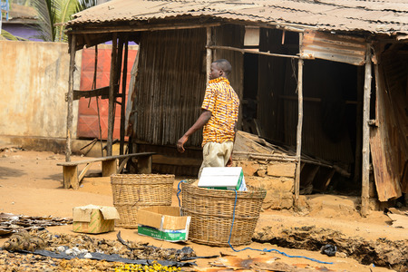 LOME, TOGO - Jan 9, 2017: Unidentified Togolese young boy in yellow shirt walks at the Lome fetish market. Togo people suffer of poverty due to the bad economyのeditorial素材